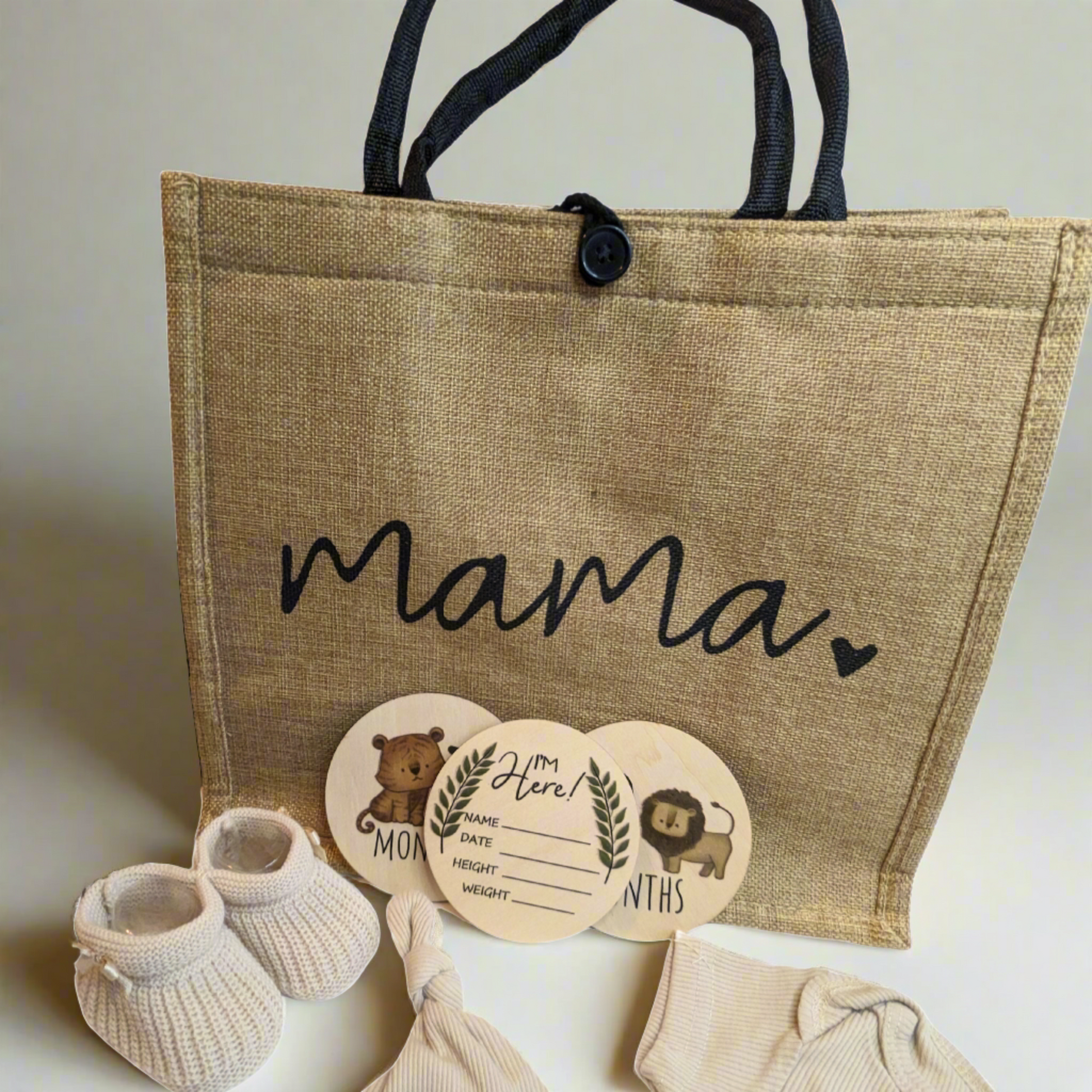 Mummy to be gift hamper including a hessian bag, eco-friendly baby clothes, milestone discs, and knit baby booties