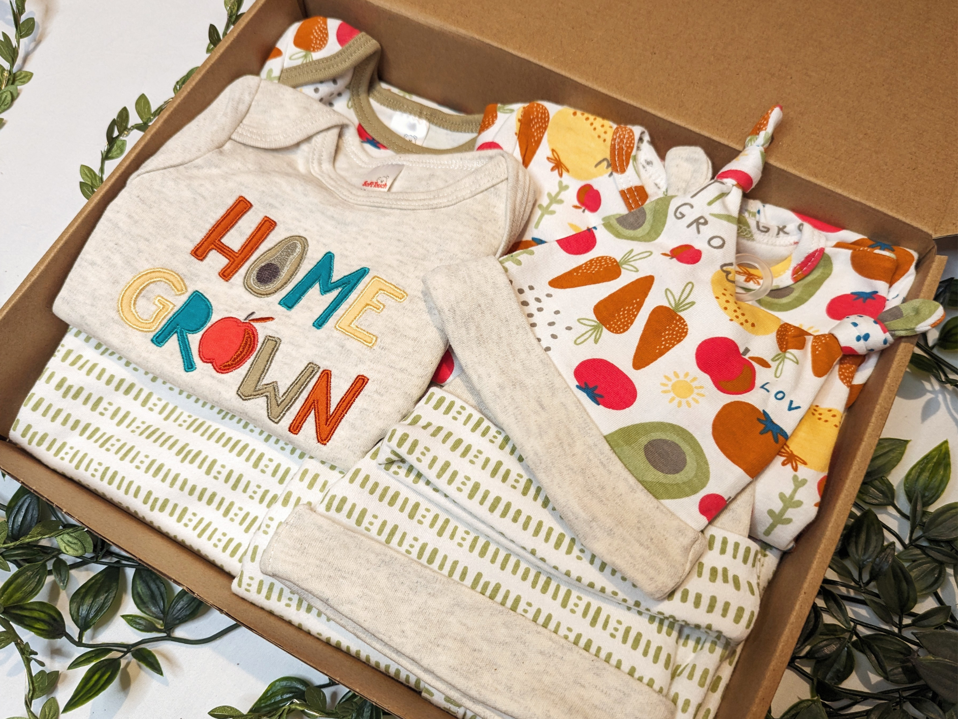 Unisex baby clothes - cute unisex baby bodysuits with vibrant vegetable-themed prints, made from 100% cotton for ultimate comfort. Explore our matching range of unisex baby clothing for a coordinated look. (Presented in an example baby gift bundle)